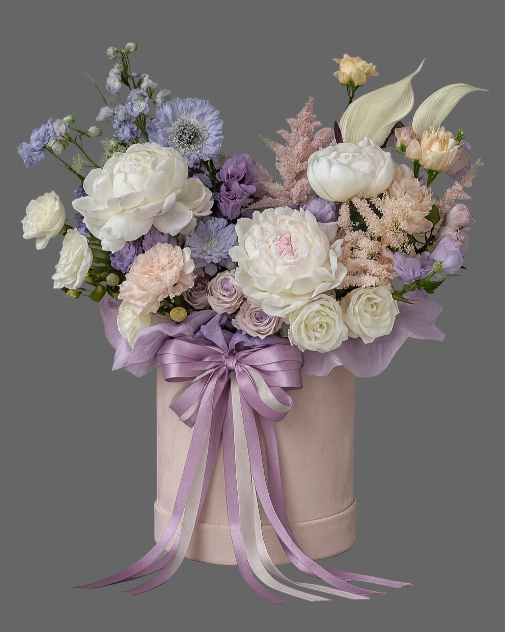 “Luxury flower box in pastel pink velvet hatbox with peonies, white garden roses, spray roses, lisianthus, carnations, scabiosa, astilbe and calla lilies, decorated with a lilac satin ribbon. Elegant floral arrangement for weddings, anniversaries, and special occasions.”