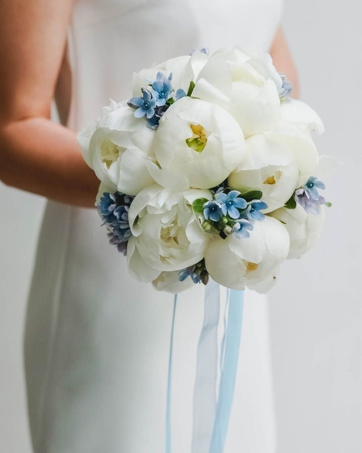 White peony wedding bouquet with blue tweedia flowers and satin ribbons, handcrafted in Miami