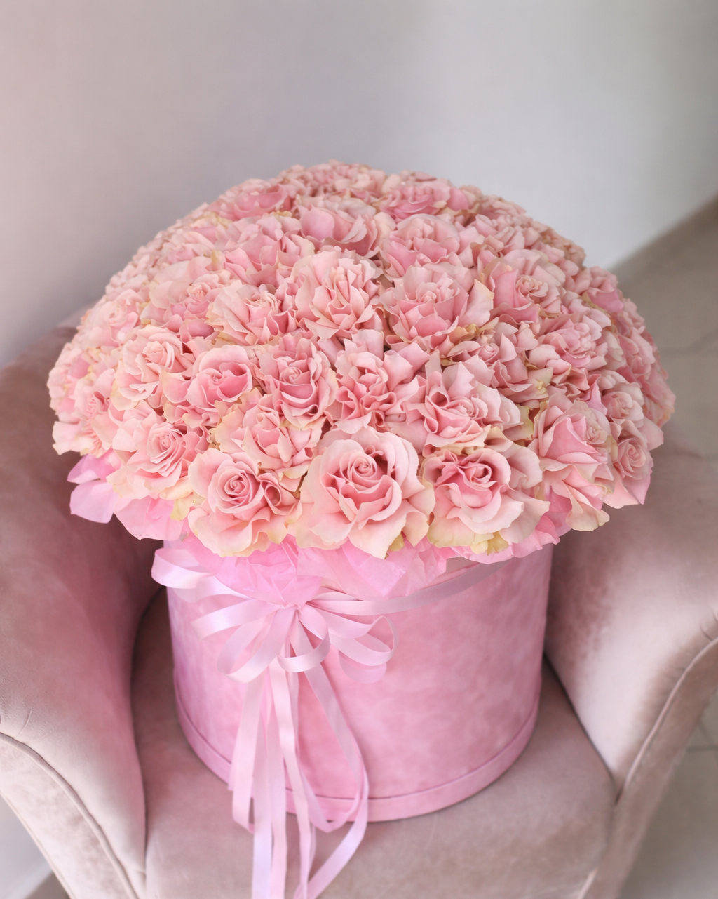 Pink rose hatbox arrangement with ribbon, photographed in Miami.