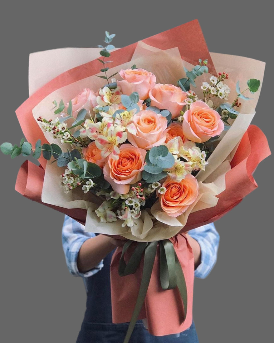 Bouquet Sunset Charm with orange roses, eucalyptus and seasonal flowers, elegant gift with flower delivery in Miami and Sunny Isles.”