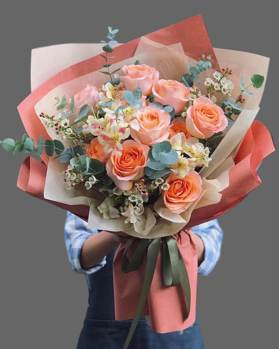 Bouquet Sunset Charm with orange roses, eucalyptus and seasonal flowers, elegant gift with flower delivery in Miami and Sunny Isles.”