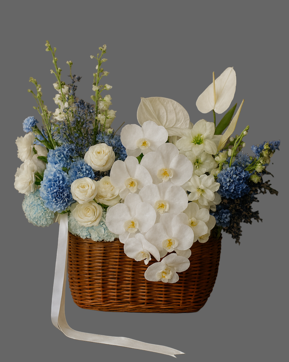 Ocean Breeze flower basket with white orchids, roses, blue hydrangeas, and anthuriums. Luxury floral arrangement for weddings, anniversaries, and special events in Miami.