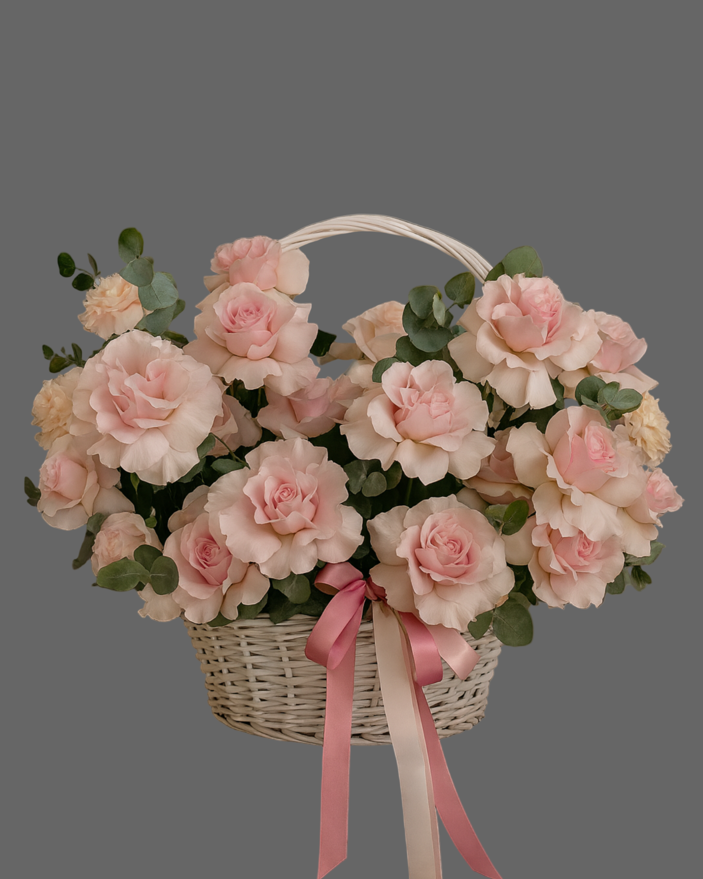 Powder pink rose basket with satin ribbons and greenery. Elegant romantic flower arrangement for gifts and occasions in Miami.