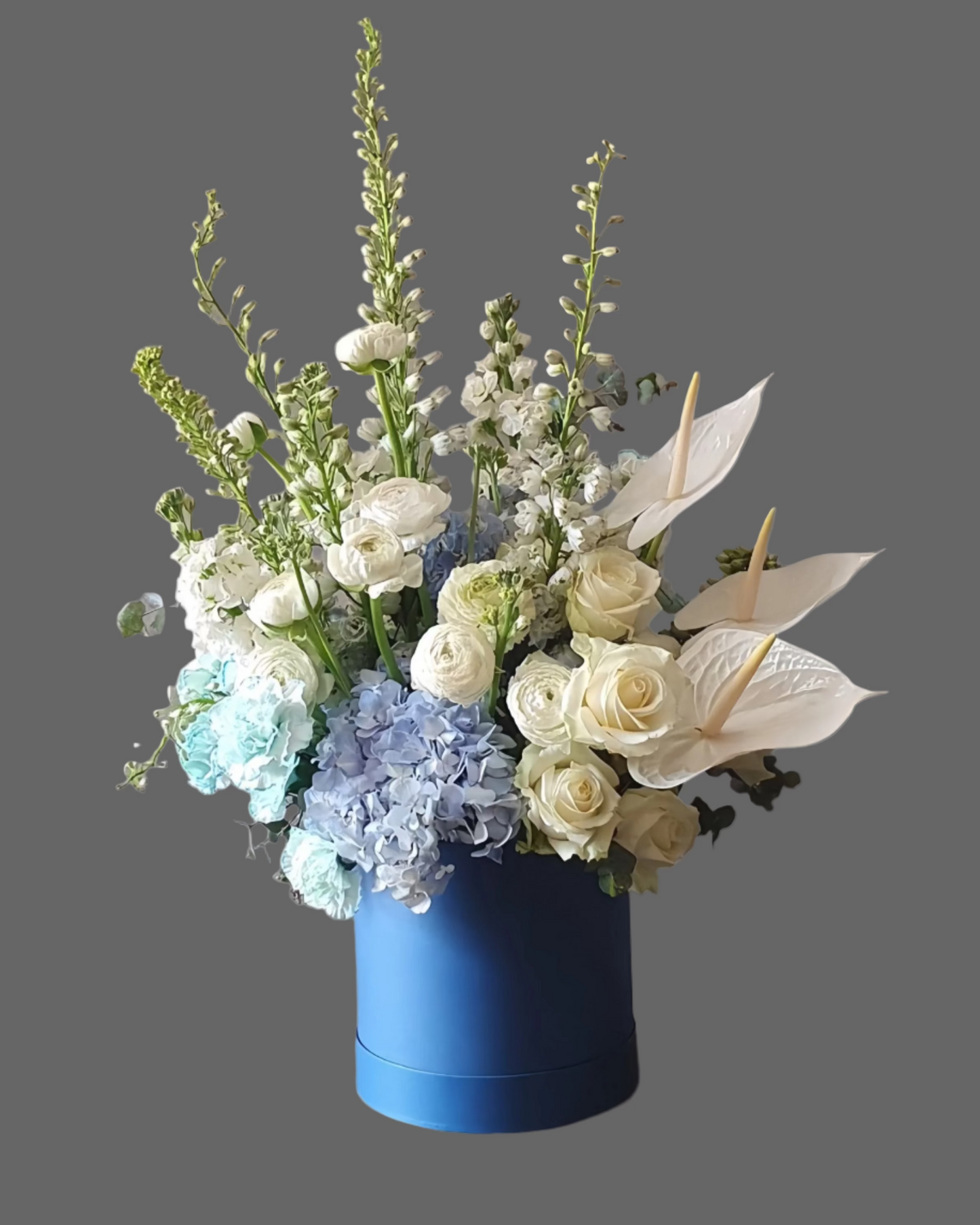 Premium flower box “Arctic Muse” with white roses, hydrangeas, and seasonal blooms in a blue hat box. Elegant arrangement for birthdays, weddings, and anniversaries.