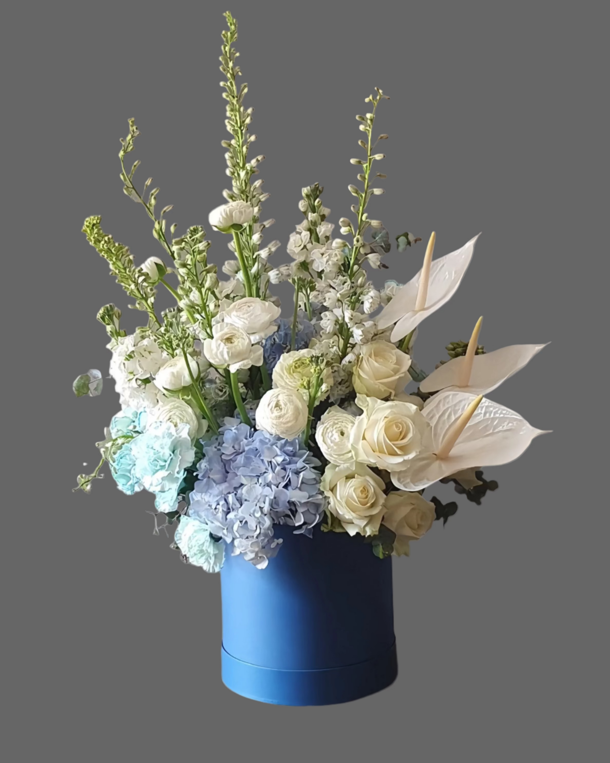 Premium flower box “Arctic Muse” with white roses, hydrangeas, and seasonal blooms in a blue hat box. Elegant arrangement for birthdays, weddings, and anniversaries.