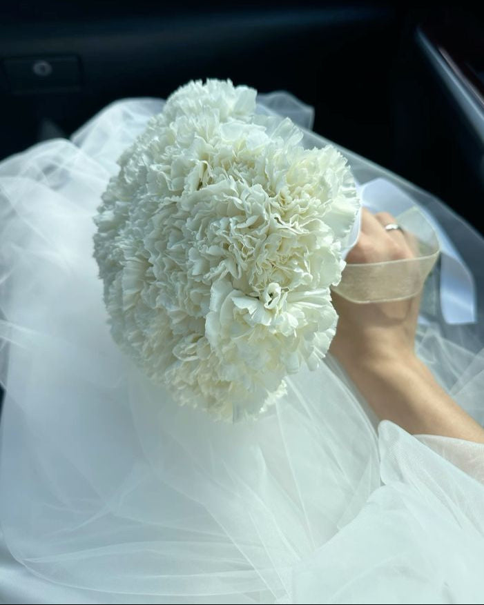 Round white dianthus wedding bouquet with satin ribbon handle, handcrafted in Miami

