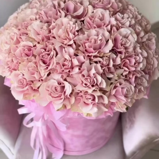 Pink rose hatbox arrangement with ribbon, photographed in Miami.