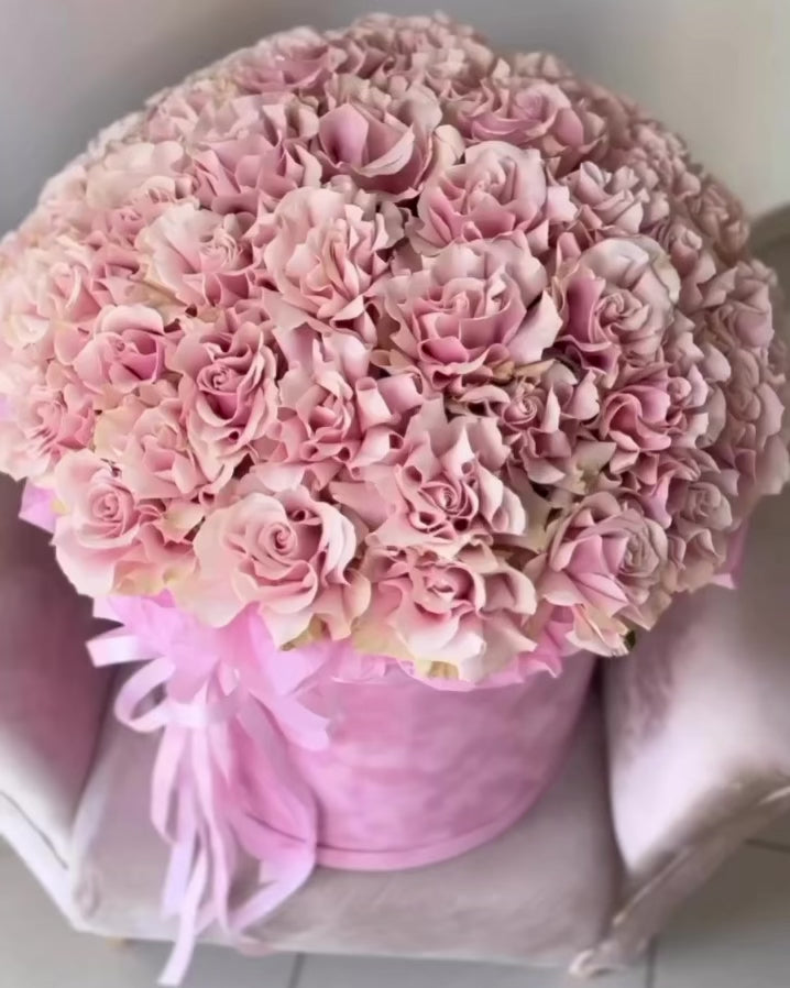 Pink rose hatbox arrangement with ribbon, photographed in Miami.
